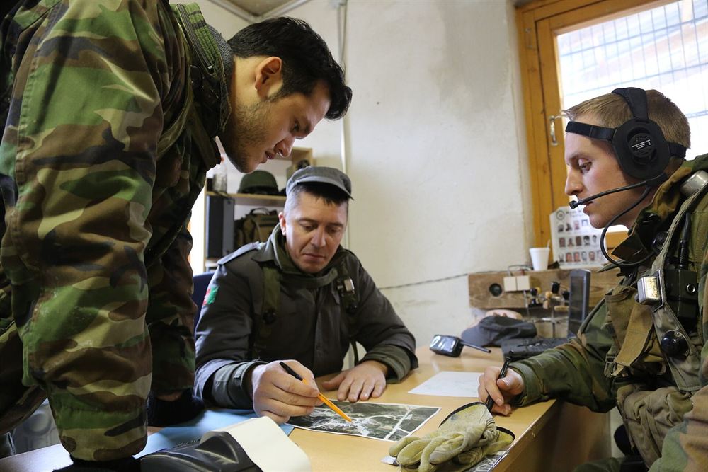 Військовослужбовці за столом розбирають документи й карту
